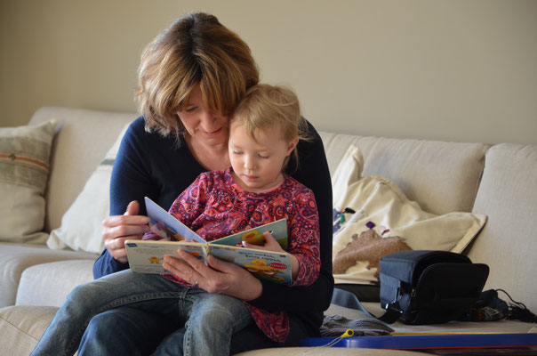 Frau und Kind lesen Bilderbuch