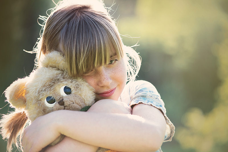 Kind beim kuscheln mit Kuscheltier